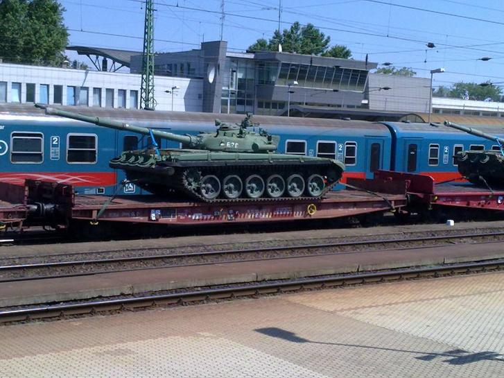 The picture shows two T-72 tanks in poor condition being transported by rail on flatcars